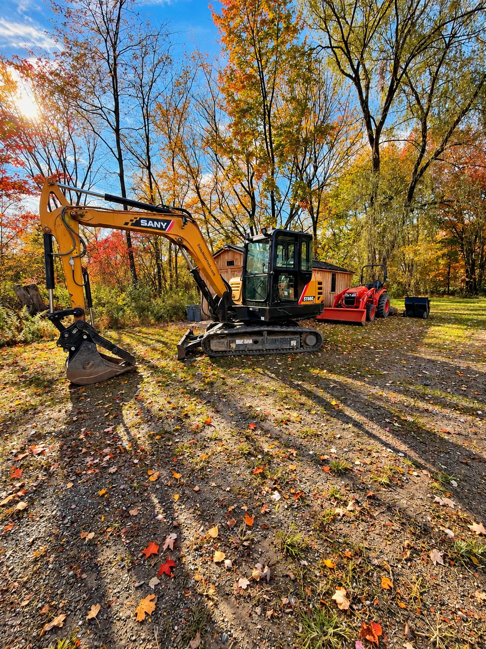 Excavator and tractor on a residential site in autumn